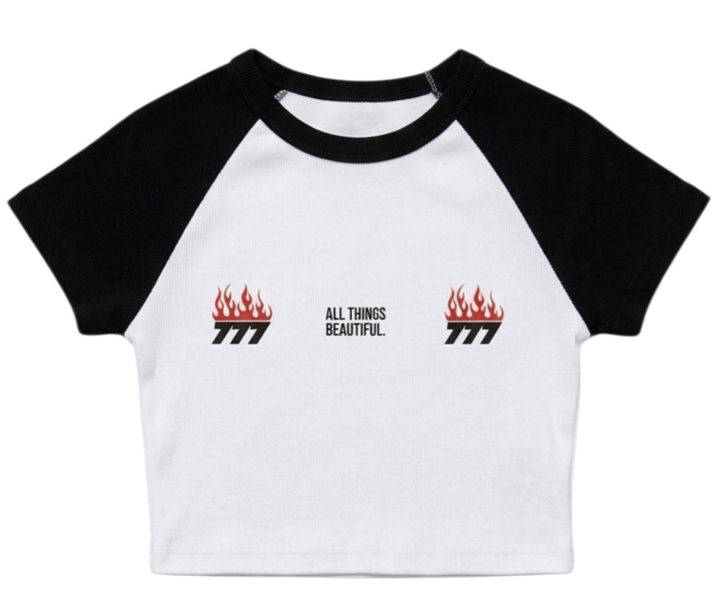 White-and-black raglan baby tee with small flame logos and “ALL THINGS BEAUTIFUL” text