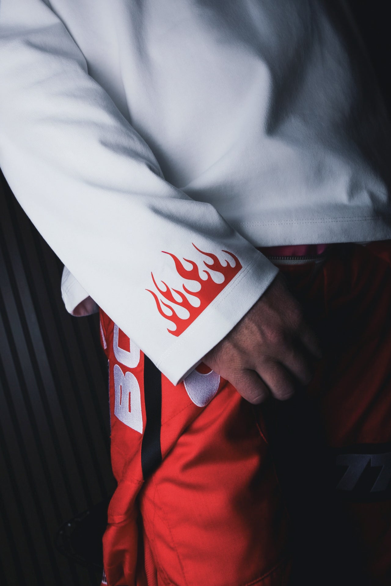 White long-sleeve shirt sleeve cuff with red flame graphic
