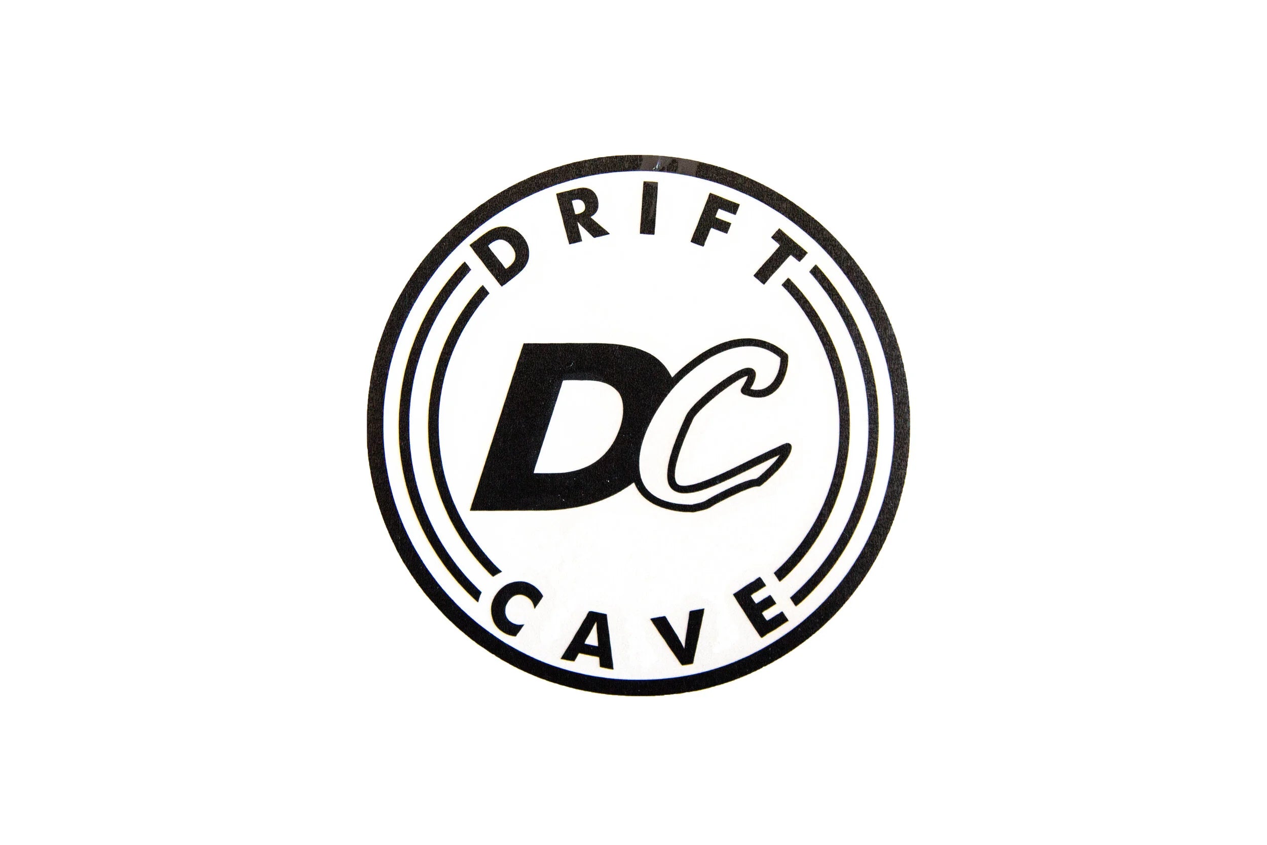 Round sticker with DC CAVE logo, black outline and white background