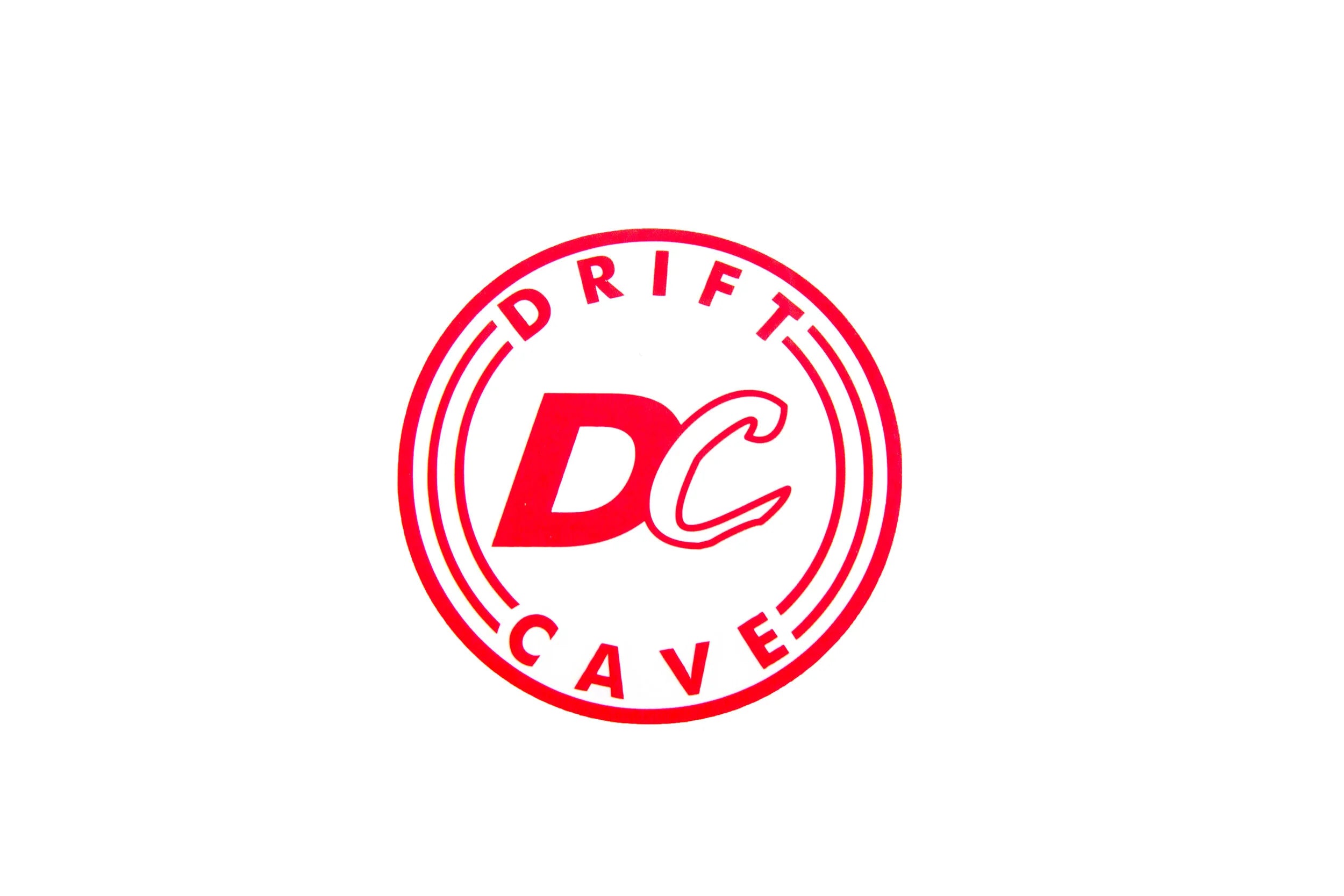 Round sticker with DC CAVE logo, red outline and red letters on white
